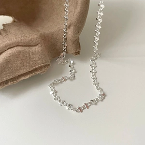 Detailed view of silver S925 flat link chain necklace on textured brown background