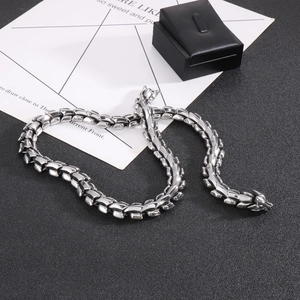 Detailed view of punk style silver steel dragon bone chain necklace on a black surface