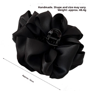 Detail of a large 16cm handmade black satin bow hair claw clip with pleated texture
