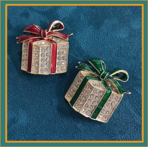 Detail of red and green enamel gift box brooches with gold plating and rhinestones