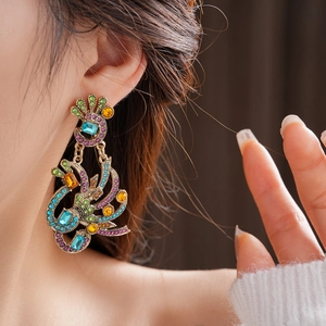 Macro shot of vintage peacock earrings with colorful rhinestones on a model ear