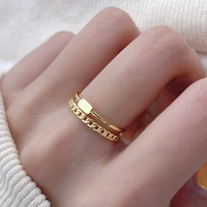 Close-up of golden double-layer chain ring with rectangular metal plate on model hand