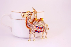 Detailed view of a gold camel keychain with sparkling rhinestones and enamel saddle details