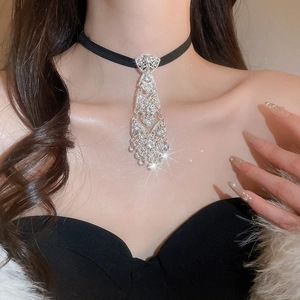 Detail of elegant silver tie-shaped choker necklace with sparkling rhinestones on model