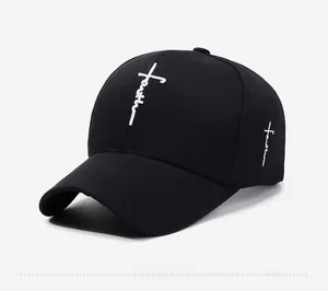 Detail of white faith cross embroidery on a black cotton twill baseball cap