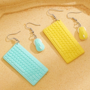 Macro detail of creative asymmetrical keyboard and mouse drop earrings in pastel colors