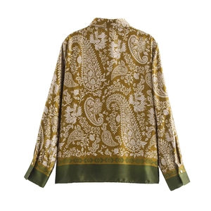 Détail de la chemise en satin vert olive avec motifs paisley et bordures contrastées