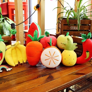 Collection of colorful fruit and vegetable plush toys including banana and carrot on wood