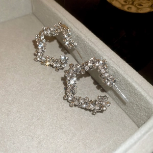 Close-up of sparkling star-shaped silver earrings with micro-pave white zircon crystals