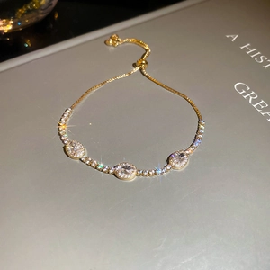 Detail of adjustable gold tennis bracelet with oval cubic zirconia and slider closure