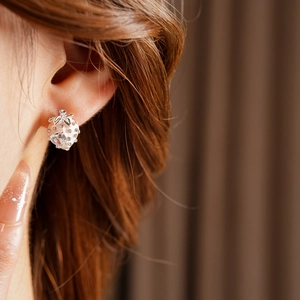 Close-up of strawberry earrings with white enamel and sparkling zircon on a model's ear