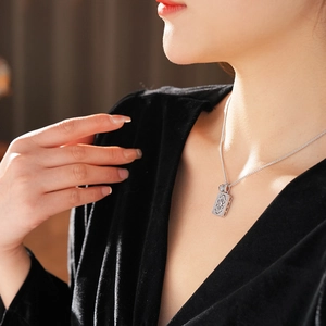 Close-up of silver hollow square pendant necklace with zircons on model neck