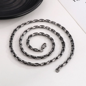 Close-up of industrial style dark metal interlocking chain links and lobster clasp