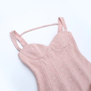 Close-up of light pink lace floral embroidery and straps on a backless mini dress