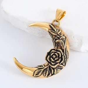 Detail of a golden moon pendant with embossed rose and leaf patterns on a white stone