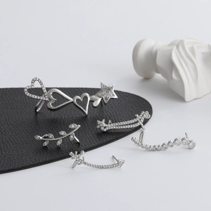 Close-up of silver zircon ear cuff set with heart and leaf motifs on black leather