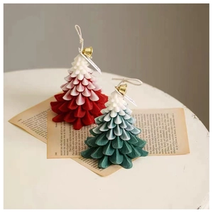 Macro detail of gradient Christmas tree candles with golden bells on retro newspaper