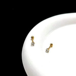 Macro detail of gold-plated surgical steel stud earrings with clear cubic zirconia stones