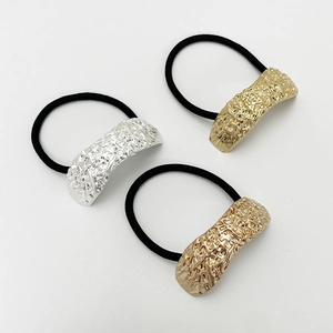 Detailed view of elastic hair ties with textured gold, silver, and rose gold metal buckles