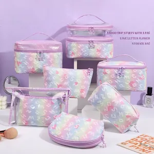 Gradient makeup bag set with heart print and star zipper on white podiums
