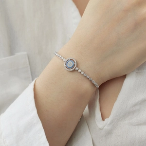 Macro shot of S925 silver devil eye bracelet with sparkling stones on woman's wrist