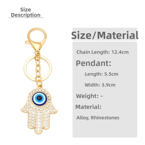 Detail of golden Hamsa hand keychain with blue Evil Eye and sparkling white rhinestones