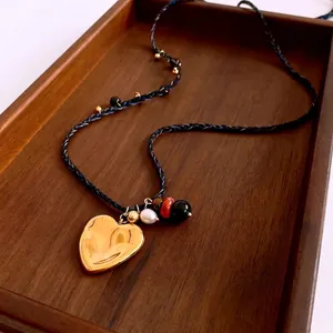 Collier style ethnique avec grand pendentif cœur doré et perles d'eau douce
