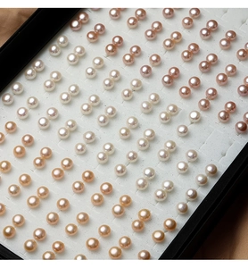 Macro view of assorted natural freshwater pearl earrings in various colors on display