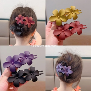 Macro detail of matte resin flower hair clips in various colors and back styling