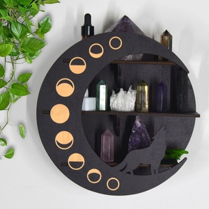 Detail of moon-shaped wooden shelf with wolf silhouette and phases cutout on white wall