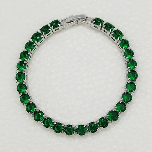 Close-up of silver tennis bracelet with emerald green round-cut cubic zirconia stones