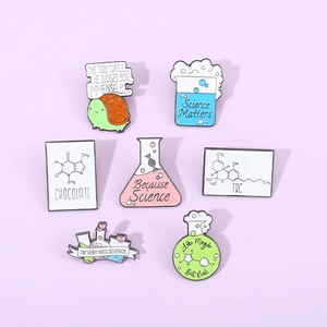 Flat lay of 7 science enamel pins with DNA, beakers and turtles on lavender background
