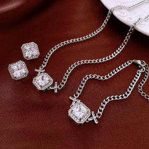 Détails d'un ensemble collier, bracelet et boucles d'oreilles en zircon carré argenté