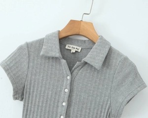 Détail de robe polo grise côtelée montrant les quatre boutons blancs et l'étiquette S