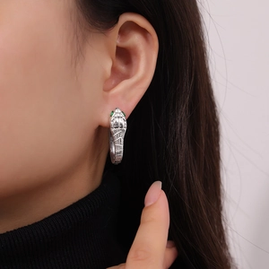 Chic silver snake head hoop earrings with green crystal eyes and textured scales