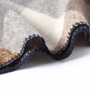 Macro shot of dark blue overlock stitching on a plaid faux cashmere winter scarf