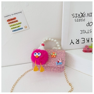 Close-up of pink sequin girls' bag with pearl handle, plush monster and metal chain