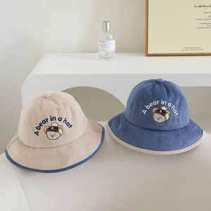 Détail de la broderie ours et du texte sur les bobs en velours côtelé pour enfants