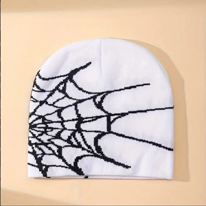 Detail shot of the white knit beanie with black spider web pattern and high-quality texture