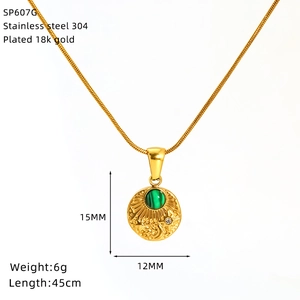 Macro detail of 18K gold-plated stainless steel sun and moon pendant with green stone