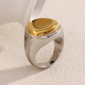 Detail of two-tone stainless steel signet ring with gold concave top and silver band