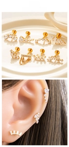 Detail of gold titanium ear piercing set with cubic zirconia and fine chain on ear
