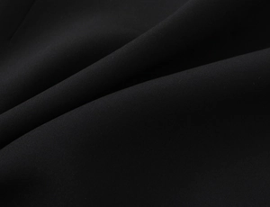 Detailed macro view of the black fabric texture and natural pleats on a polka dot dress