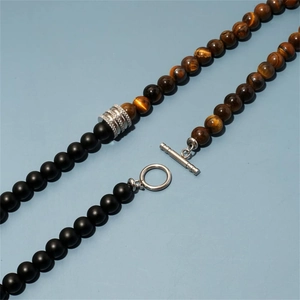 Macro shot of 8mm obsidian and tiger eye beads with patterned silver metal connector
