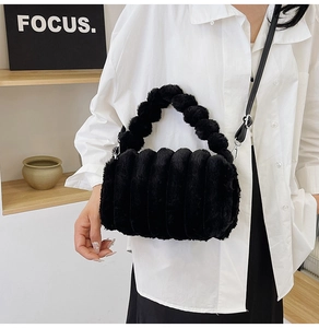 Detail of black plush handbag with striped texture held by model in casual outfit