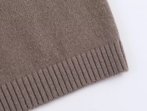 Détail du cardigan en tricot marron montrant les poignets côtelés et la fourrure