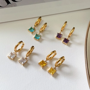 Detail view of square zircon earrings in blue, purple, white, and yellow with gold base