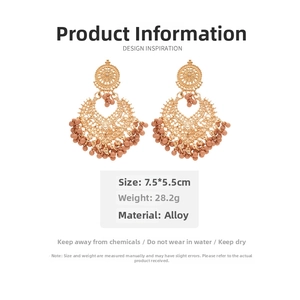 Detail view of large gold bohemian earrings with lace patterns and cinnamon beads