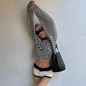 Detail of a long-sleeve striped crop top featuring black and white horizontal patterns