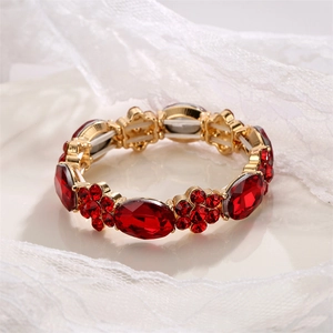 Macro detail of red gemstones and gold floral patterns on stretch bracelet band